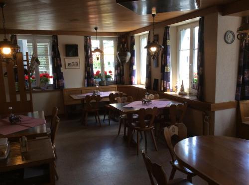 a dining room with tables and chairs and windows at Hotel / Restaurant Post in Eschlikon