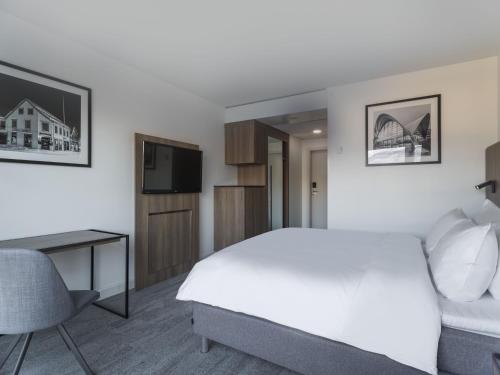 a bedroom with a bed and a desk and a television at Radisson Blu Hotel Tromsø in Tromsø