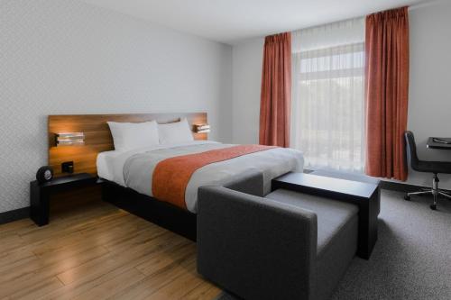 una camera d'albergo con letto e sedia di Littoral - Hôtel & Spa a Québec