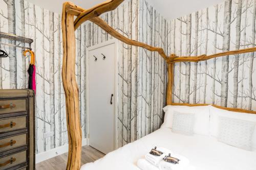 una camera da letto con letto e carta da parati con alberi di West Bow - Magical Harry Potter-Inspired Flat near Edinburgh Castle a Edimburgo