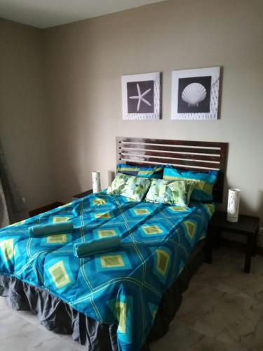 a bed with a blue comforter in a bedroom at WHITE SHARK RESORT in Ponta do Ouro