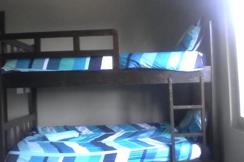 a bedroom with two bunk beds with blue pillows at WHITE SHARK RESORT in Ponta do Ouro
