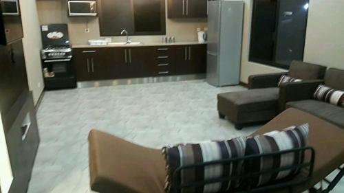 a living room with a couch and a kitchen at WHITE SHARK RESORT in Ponta do Ouro