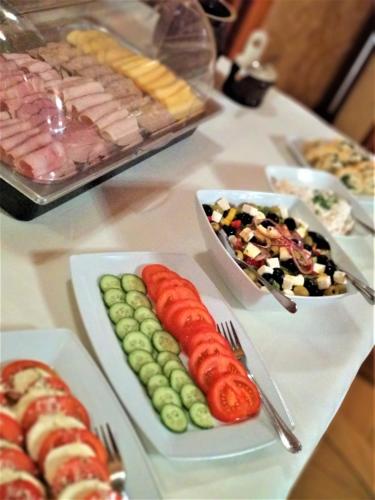 a table topped with plates of food with meats and vegetables at Senator Gran Via in Będziemyśl