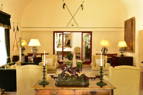 a living room with a table and chairs and a clock at Pousada Convento de Vila Viçosa in Vila Viçosa