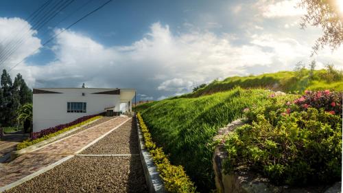 a house on the side of a hill with flowers at Apartamento - ApartaSuite ARGUS in Paipa