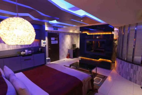 a bedroom with a bed and a couch and lights at Yosemite Motel - Taiyuan Branch in Taichung