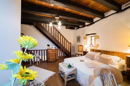 a bedroom with a bed and a living room at Au coeur de Beynac, une maison de caractère avec jardin terrasse in Beynac-et-Cazenac