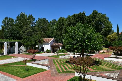 a garden with trees and a building in the background at Pousada Convento de Vila Viçosa in Vila Viçosa