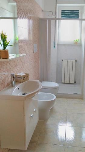 a white bathroom with a sink and a toilet at Il Soffione Home in Salerno