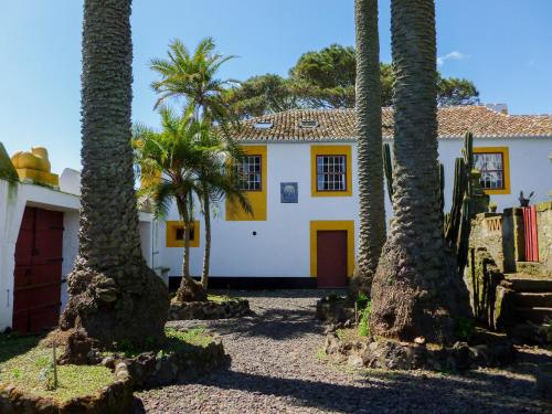 a house with palm trees in front of it at Quinta do Espírito Santo in Angra do Heroísmo