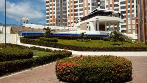 a building with a garden with bushes and flowers at Reserva del Peñon in Girardot