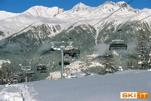 a ski lift with people on it on a snowy mountain at Appartamenti Vacanze Casa -Residence Albare - check in Vacanze Casa - Marilleva 900 in Marilleva