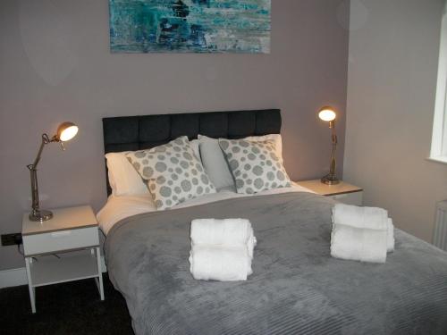 a bedroom with a large bed with two night stands at Westpark Apartment in East Kilbride