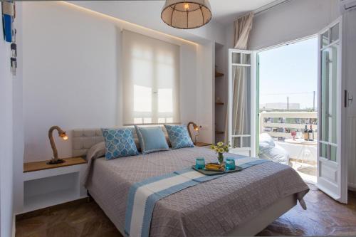 a bedroom with a bed and a large window at JKG OIKIA in Agia Anna Naxos