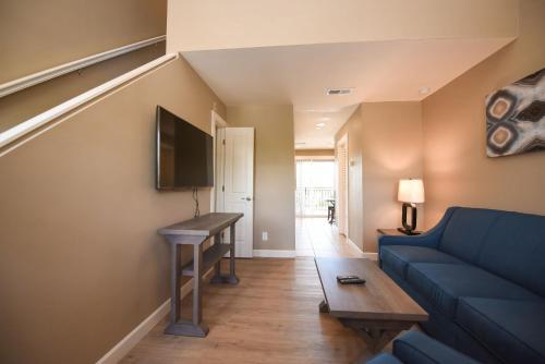 a living room with a blue couch and a table at Waterside Suites and Marina in Key Largo