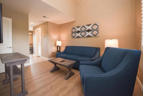 a living room with two blue chairs and a table at Waterside Suites and Marina in Key Largo