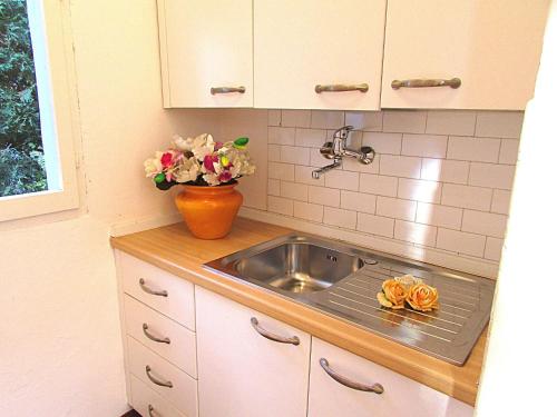 una cucina con lavandino e vaso di fiori di Fiori a Bibione