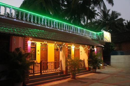 a house with christmas lights on the side of it at Sai Homestay in Malvan