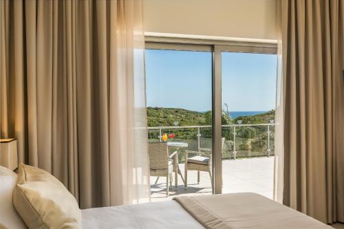 a bedroom with a bed and a view of a balcony at Caneiros Luxury House & Suites in Ferragudo