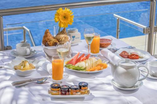 una mesa con desayuno de fruta y zumo en Caneiros Luxury House & Suites, en Ferragudo