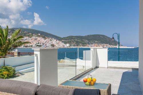 a balcony with a table with fruit on it at Olia Green Residence in Skopelos Town