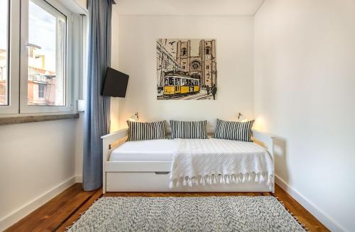 a bedroom with a white bed and a painting on the wall at Marquês de Pombal Metropolitan Flat in Lisbon