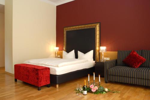 um quarto com uma cama, uma cadeira e um espelho em Klostergasthof Raitenhaslach em Burghausen