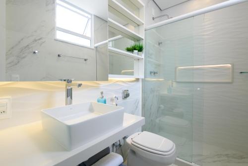 a white bathroom with a sink and a toilet at Studio em Copacabana a 180m da praia | RP 23/404 in Rio de Janeiro