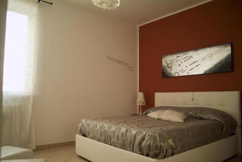 a bedroom with a bed with a picture on the wall at B&B A Casa di Mael in San Costanzo