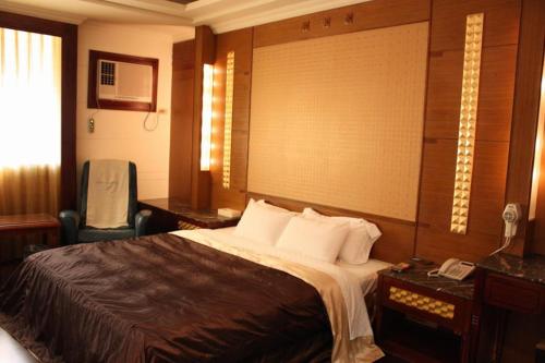 a hotel room with a bed and a telephone at Yatelanda Motel in Shalu