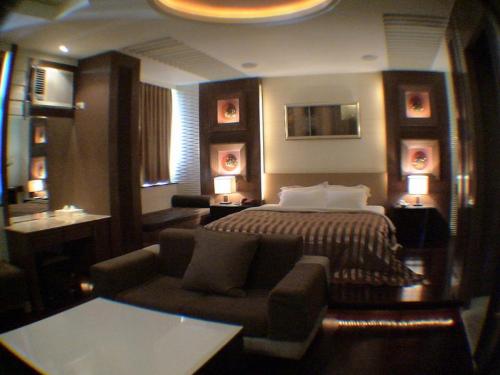 a hotel room with a bed and a couch at Yatelanda Motel in Shalu