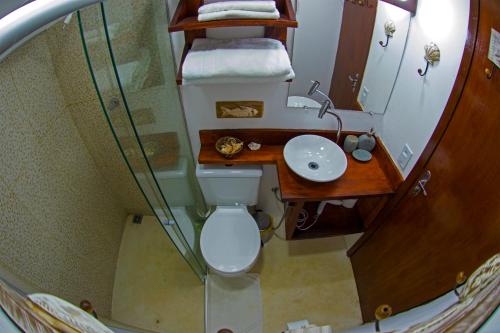 a small bathroom with a toilet and a sink at Casinhas da Julieta in Morro de São Paulo