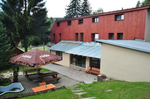 a building with a picnic table and an umbrella at Chata Bajama in Bedřichov