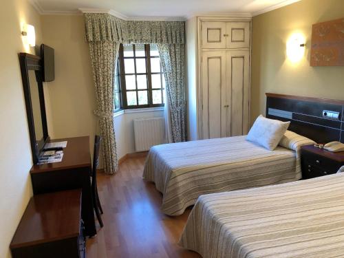 カルダス・デ・レイスにあるHotel Senaのベッドが2つと窓があるホテルの部屋
