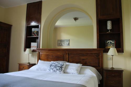 una camera con un grande letto e un grande specchio di Hotel Tempio di Apollo a Olgiata