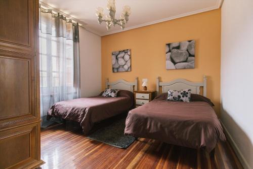 une chambre avec deux lits et un lustre dans l'établissement Centro Río Lobos, à Hontoria del Pinar