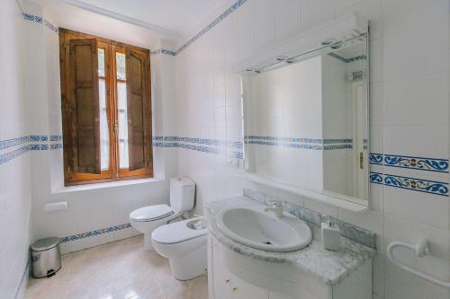 une salle de bain blanche avec toilettes et lavabo dans l'établissement Centro Río Lobos, à Hontoria del Pinar