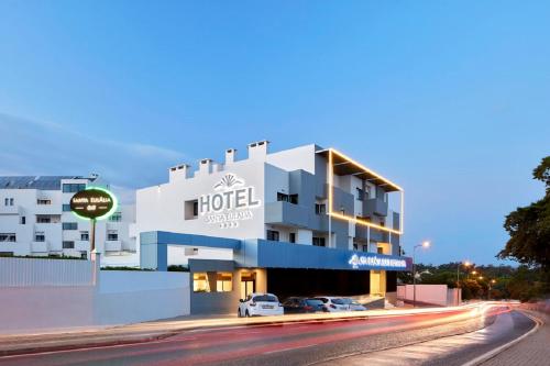 a hotel with cars parked in front of it at Santa Eulalia Hotel & Spa in Albufeira