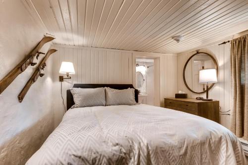 a bedroom with a large white bed and a mirror at Ski Tip Lodge by Keystone Resort in Keystone