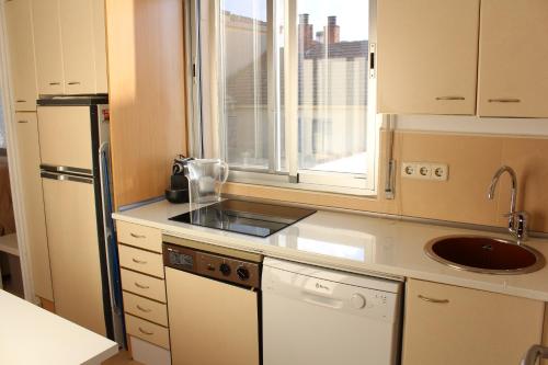 una pequeña cocina con fregadero y ventana en VUT Skyline en Segovia