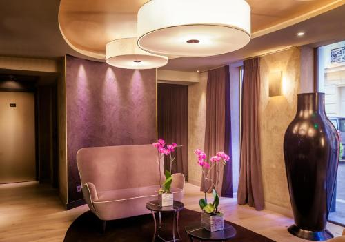 a lobby with a chair and a vase of flowers at Hotel Armoni Paris in Paris