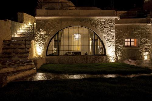a building with a large window with lights on it at Hezen Cave Hotel in Ortahisar