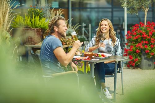 a man and a woman sitting at a table drinking beer at Landhotel Wilder Mann in Eggingen