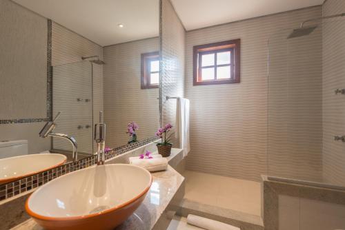 a bathroom with a large tub and a shower at Ilha Branca Exclusive Hotel in Búzios