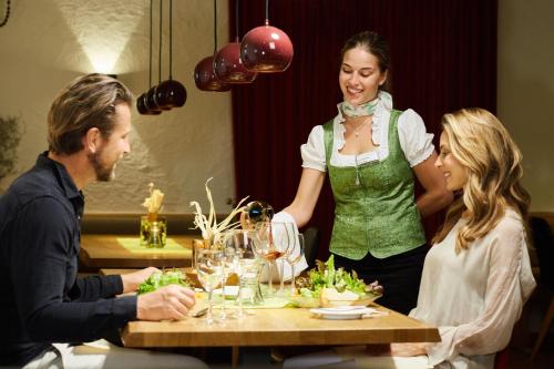 a woman standing next to a table in a restaurant at Landhotel Wilder Mann in Eggingen
