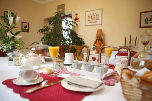 a dining room table with a christmas table set with cups and dishes at Gîte - Chambre d Hôtes Les 4 vents Guingamp in Saint-Agathon