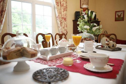 a dining room table with a table set with breakfast food at Gîte - Chambre d Hôtes Les 4 vents Guingamp in Saint-Agathon