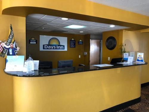a lobby with a yellow counter in adds inn office at Days Inn by Wyndham Neenah in Neenah