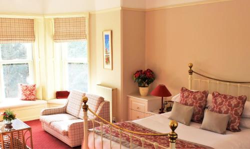 a bedroom with a bed and a couch in a room at Penmorvah Manor Hotel in Falmouth